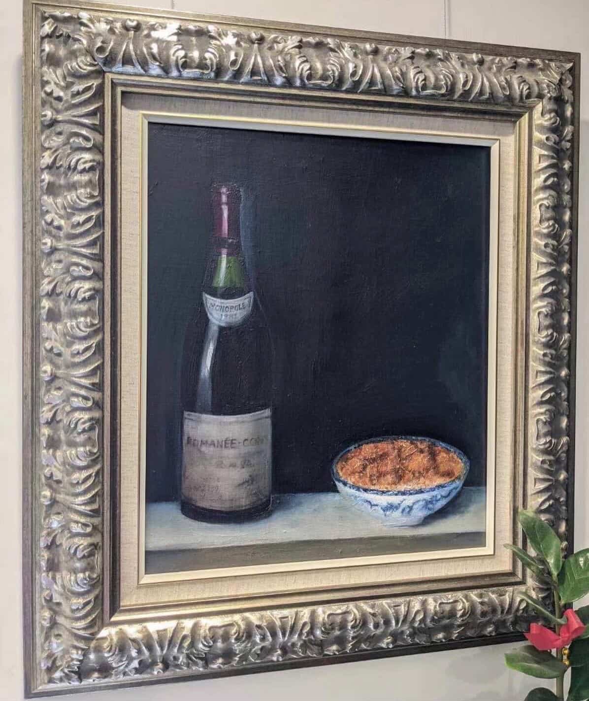 Chiaroscuro still life with a wine bottle and patterned bowl.